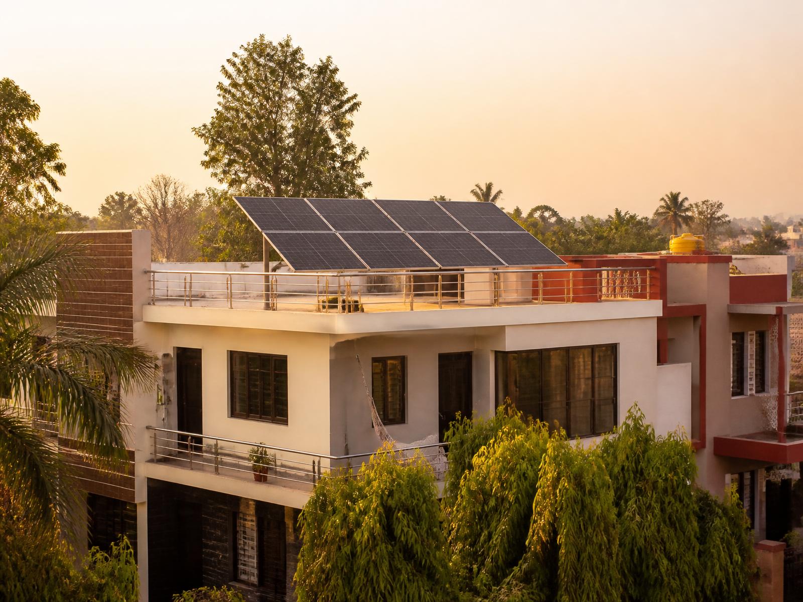 Indian independent house in Shahjahanpur with professionally installed rooftop solar panels at golden hour